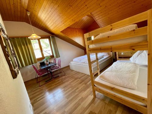 a bedroom with two bunk beds and a table at central beauty scenery apartment in Interlaken
