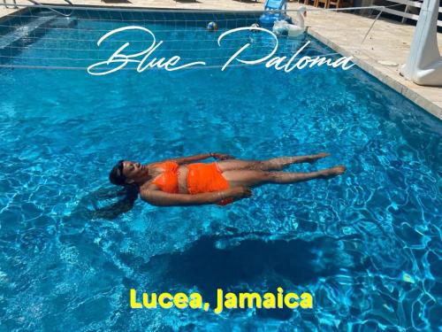 una mujer está tumbada en una piscina en Blue Paloma Bed & Breakfast, en Lucea