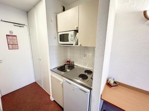 a small kitchen with a sink and a microwave at ValHôtel - Hôtel-Résidence Châteaufort in Châteaufort