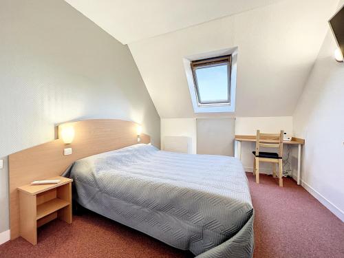 - une chambre avec un lit, un bureau et une fenêtre dans l'établissement ValHôtel - Hôtel-Résidence Châteaufort, à Châteaufort