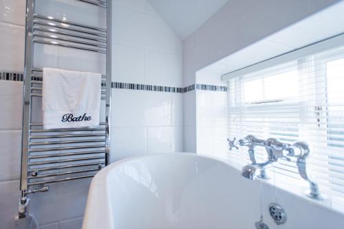 une salle de bain blanche avec une baignoire et un lavabo dans l'établissement Stay in Westow, à Westow