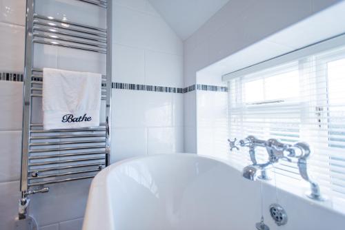 a white bathroom with a tub and a sink at Stay in Westow in Westow