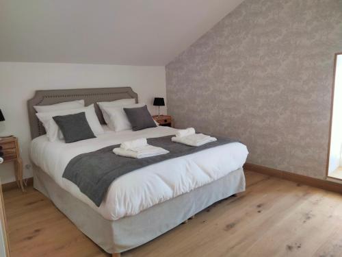 a bedroom with a large bed with two towels on it at Les Chambres de Moulière in Liniers