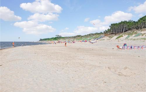 un grupo de personas en una playa con gente volando cometas en Holiday Home Rowy Ul Bukowa, en Rowy