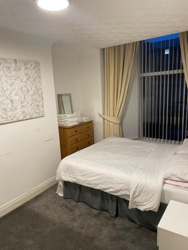 1 dormitorio con 1 cama, vestidor y ventana en Apartments Azalea Terrace, en Sunderland
