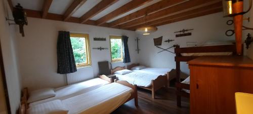 a room with two beds and a loft at De Linde, boerderij in Drenthe voor 15 tot 30 personen in Linde