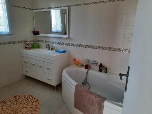 La salle de bains blanche est pourvue d'une baignoire et d'un lavabo. dans l'établissement CLOS DES ROMPUDES, à Aramon