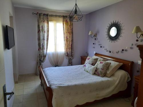 a bedroom with a bed with a mirror and a window at CLOS DES ROMPUDES in Aramon