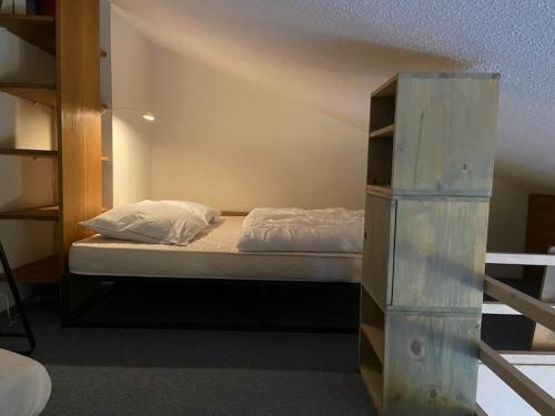 une chambre avec un lit et une étagère dans l'établissement VALFREJUS résidence chaviere, à Modane