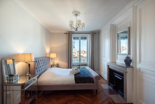 - une chambre avec un lit, une cheminée et des fenêtres dans l'établissement Le Dandy - Grand T3 au pied du métro Garibaldi, à Lyon