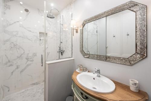 een badkamer met een wastafel en een spiegel bij Le Dandy - Grand T3 au pied du métro Garibaldi in Lyon