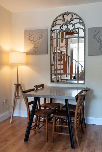 a dining room table with chairs and a mirror at Kylemore House boutique apartments - Connemara Suite in Kylemore