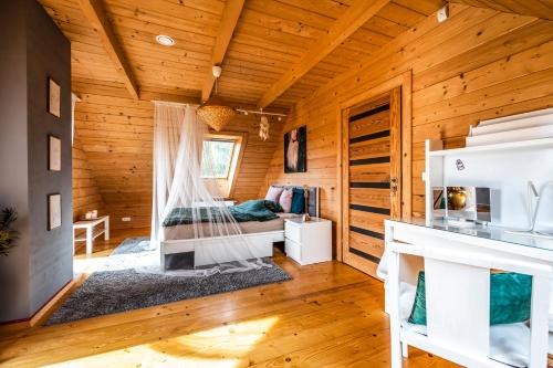 1 dormitorio con 1 cama en una cabaña de madera en Villa Carmen, en Korzkiew