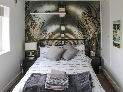 ein Schlafzimmer mit einer mit Graffiti bedeckten Wand in der Unterkunft Hornby Cottage in Saint Michaels on Wyre