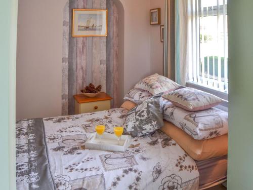 une chambre avec un lit et deux lunettes dans l'établissement Marsh Bungalow, à Halvergate