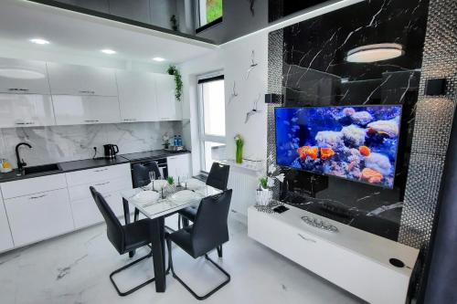 a kitchen with a fish tank on the wall at Apartament 10 Glamour Aquapark Reda in Reda