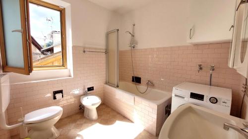 a bathroom with a toilet and a sink and a tub at Casa Ciajeole in Moena