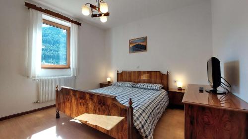 a bedroom with a bed and a television in it at Casa Ciajeole in Moena