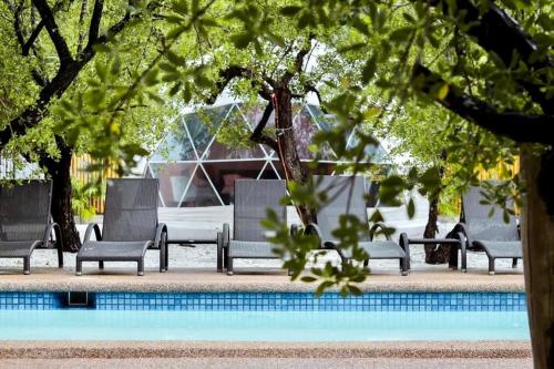 a group of chairs sitting next to a pool at Aquamare Beach Camp Resort in Siquijor