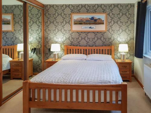 a bedroom with a large bed with two night stands at Cuiltean in Gairlochy