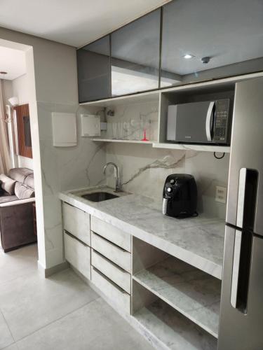 uma cozinha com um lavatório e um micro-ondas em Flat Île de Pipa Resort - Centro em Pipa