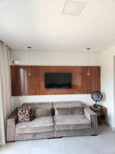 a living room with a couch and a flat screen tv at Île de Pipa - Flat Resort in Pipa