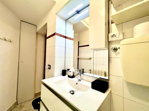 La salle de bains blanche est pourvue d'un lavabo et d'un miroir. dans l'établissement Kibilù - Via Colonna con parcheggio vicinanze Ospedale di Circolo, à Varèse