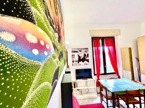 - un salon avec une table et un mur coloré dans l'établissement Kibilù - Via Colonna con parcheggio vicinanze Ospedale di Circolo, à Varèse