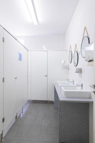 a bathroom with two sinks and two mirrors at Ínsua Hostel in São Pedro do Sul