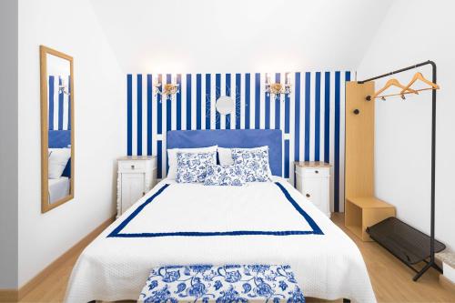 a bedroom with a bed and blue and white stripes at Ínsua Hostel in São Pedro do Sul