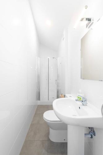 a white bathroom with a sink and a toilet at Ínsua Hostel in São Pedro do Sul