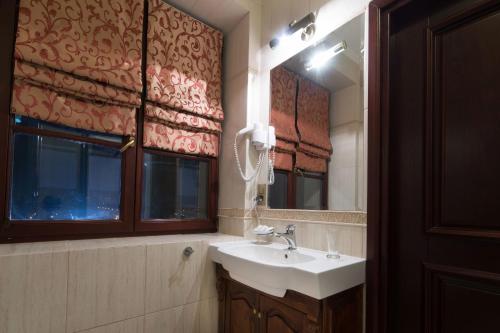 a bathroom with a sink and a mirror at Pałac Bursztynowy in Włocławek