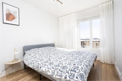 a white bedroom with a bed and a window at Renovated apartment metro, parking included, near Porte Versaille in Vanves