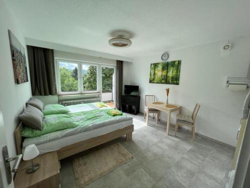 una camera con letto, scrivania e finestra di Ruhiges und klimatisiertes Apartment a Stoccarda