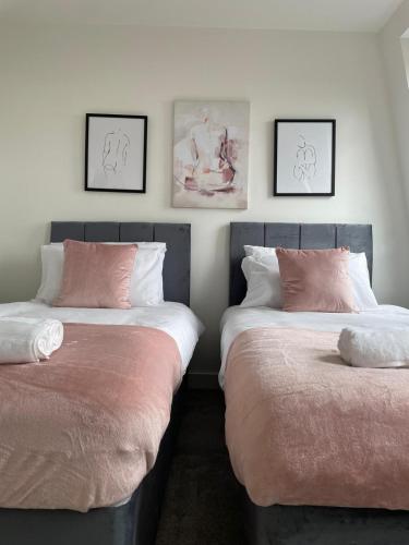 two beds sitting next to each other in a bedroom at Premier Suite- Bedford city centre with free gym & parking in Bedford