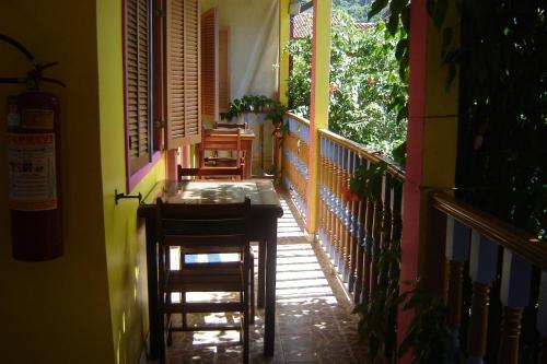 a balcony with chairs and a table on a house at Pousada Pedacinho de Céu in Abraão