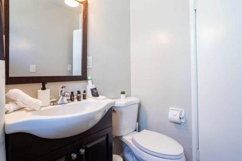 a bathroom with a sink and a toilet and a mirror at Sleek Spacious Simply Beautiful 2bd 1ba entire apt in Los Angeles