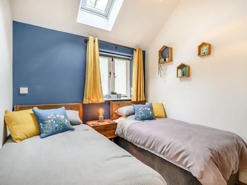 two beds in a room with a window at The Old Stables - Uk38576 in Aston Cantlow
