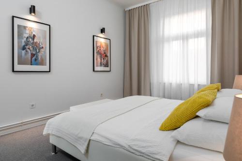 ein Schlafzimmer mit einem weißen Bett und einem Fenster in der Unterkunft Zagreb City Apartments in Zagreb