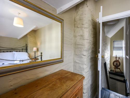 a mirror on the wall of a bedroom with a bed at Bwthyn Llys machynlleth Old Court House in Machynlleth