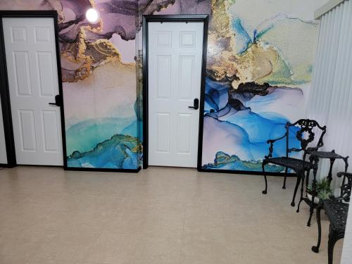 two doors in a room with a painting on the wall at Orangewood & 51Ave Homestay - Not a Hotel in Glendale