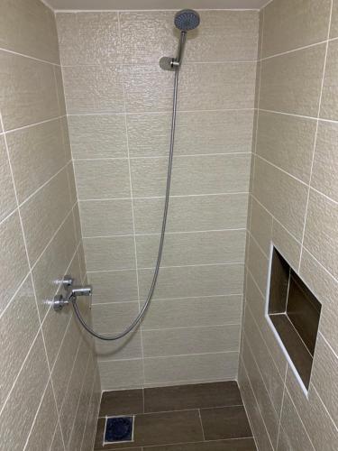 a shower with a hose in a bathroom at Appart de proximité à bayo in Berkawe