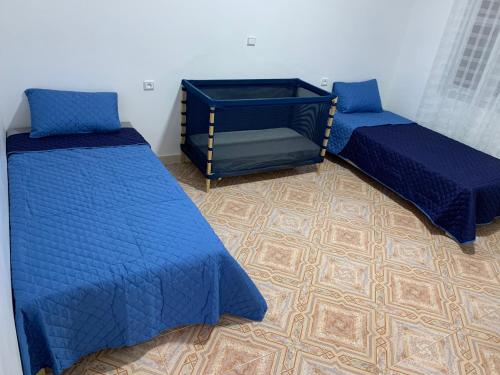 - 2 lits dans une chambre avec des couettes bleues dans l'établissement Appart de proximité à bayo, à Berkane