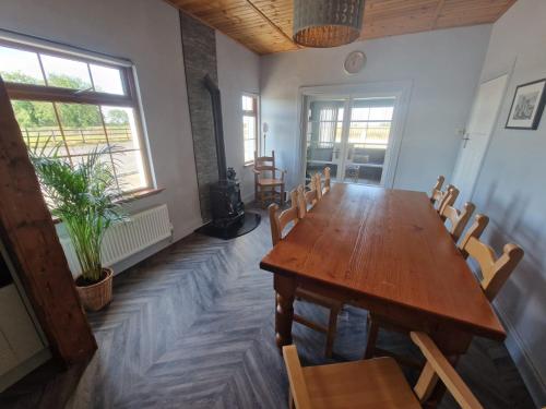 a dining room with a wooden table and chairs at The.deerparkcottage in Lurgan