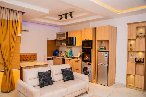 a living room with a couch and a kitchen at VINEWOOD SUITE+GYM, RHODABODE APT, NILE in Abuja
