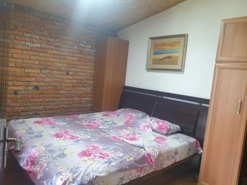 a bed in a room with a brick wall at Villa SEMI in Gjilan