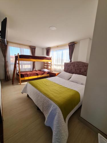 um quarto com uma cama grande e um cobertor amarelo em Tauko tu casa em Paipa