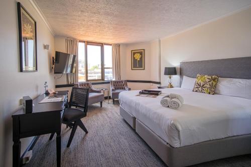 Habitación de hotel con cama y escritorio con ordenador en Rydges Southbank Townsville, en Townsville