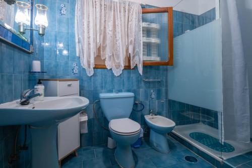 a blue bathroom with a toilet and a sink at Piso cerca del mar en Alcalá in Alcalá
