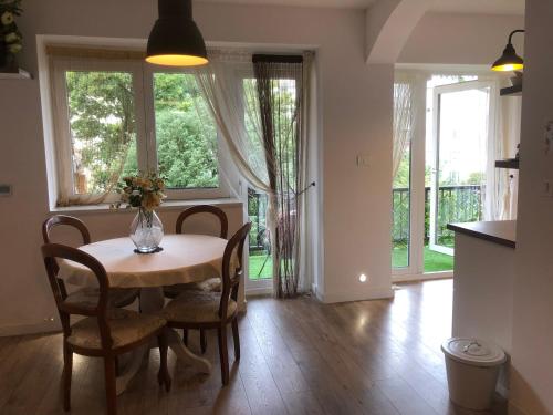 una sala da pranzo con tavolo, sedie e finestre di Meduliceva apartman a Zagabria
